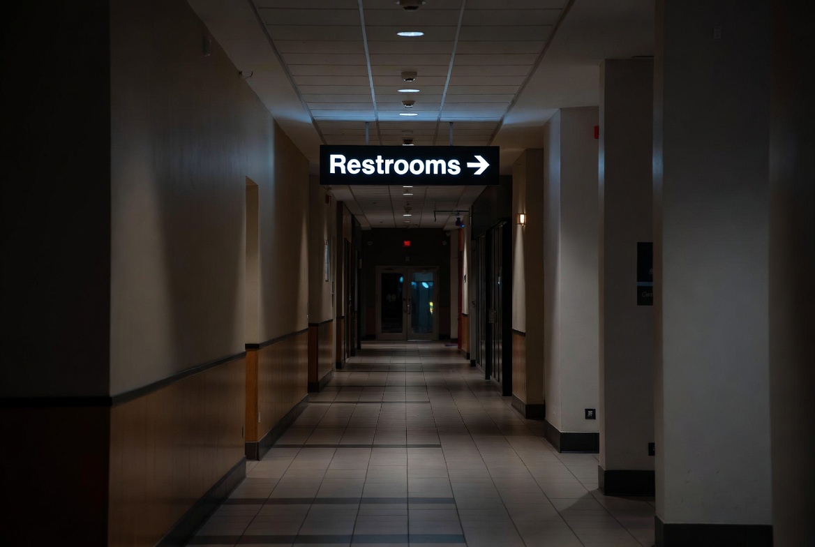 Illuminated Restroom Sign In Corridor